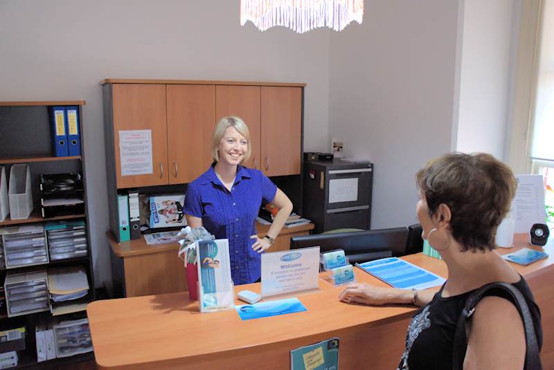 woman being served by staff behind the counter of Free2move Physiotherapy foyer