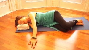 Jodie Krantz lying on her side on a mat with one arm out to the side and the other sliding along top of if in the Feldenkrais studio at Free2move