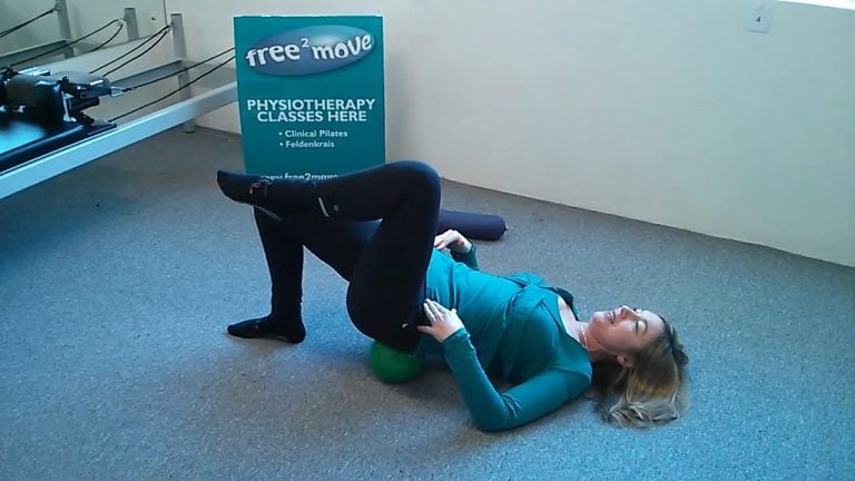 Jodie Krantz in a pilates studio doing a pelvic stability exercise with a mini-ball